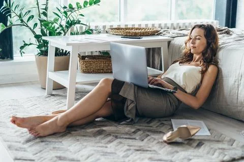 Young woman using laptop while lying on floor in bedroom at home Stock Photos