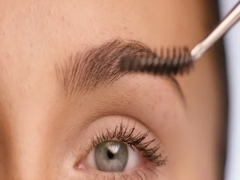 Young woman using make-up for her eyebrowns Stock Footage 78348456