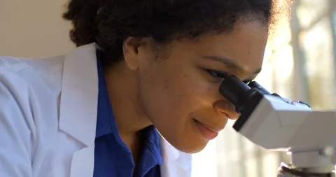 Young woman using a microscope. Видео 88372382