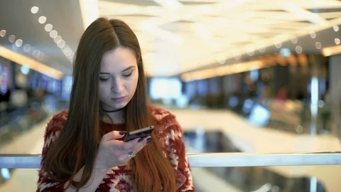 Young Woman using Mobile in Shopping Mall Stock Footage