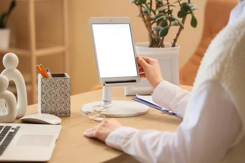 Young woman using modern tablet computer with blank screen on table at home,  Stock Photos