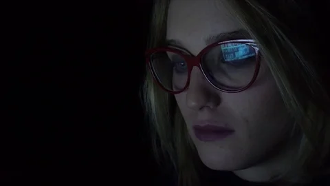 Young woman using notebook at night, close-up Stock Footage 83635617