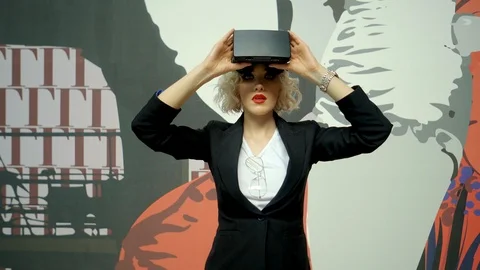 Young woman is using an optical head-mounted display and moving on mall Video stock 86574777