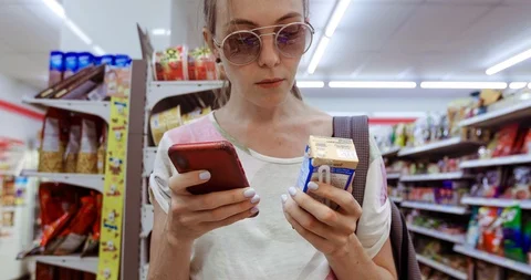 Young woman using phone checking box in shop Stock Footage 100255099