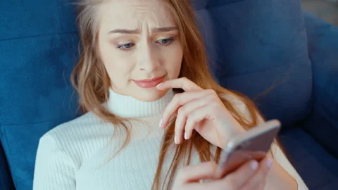 Young woman using phone while sitting on sofa at home. Vídeo Stock 87041254