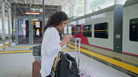 Young woman using phone while waiting train boarding at the station Stock Footage 232016816