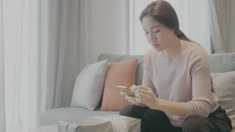 Young Woman Using Phone While Sitting on Sofa Stock Footage 314511663