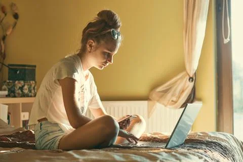 Young woman using portable computer and mobile phone Stock Photos