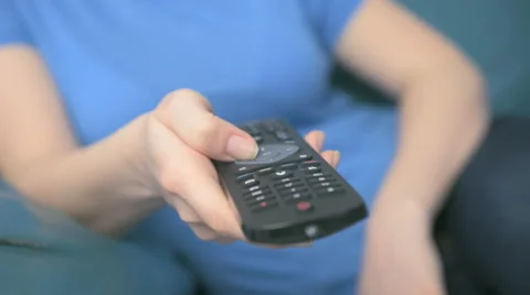 Young woman using remote control in living room Stock Footage 62909637