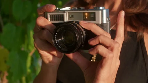 Young woman using a retro camera in nature Vídeo Stock 265978116