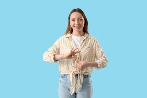 Young woman using sign language on blue background Stock Photos