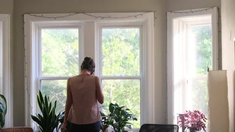 Young woman using smart phone in the morning in front of the window Stock Footage 219568604
