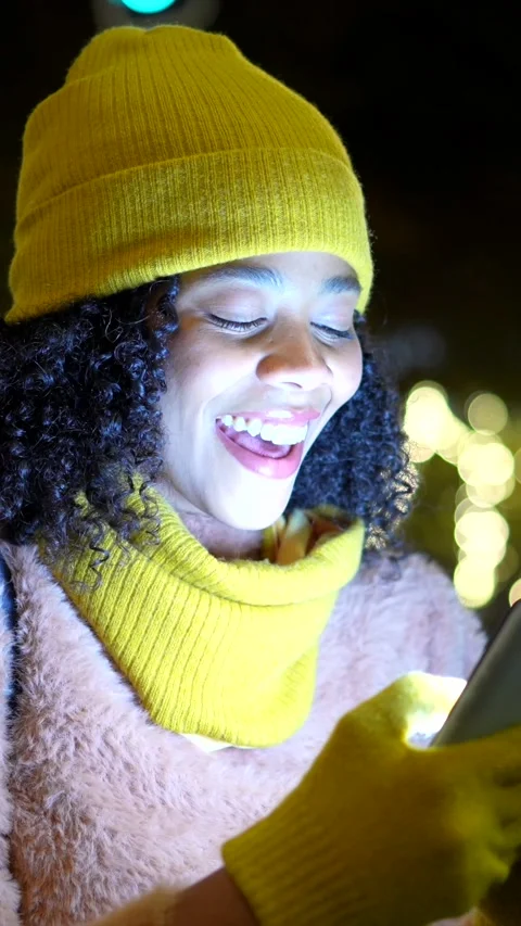Young woman using smartphone and smiling at night Stock Footage 297910203