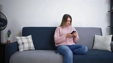 Young woman using smartphone, browsing social networks, checking news. Video stock 155652127