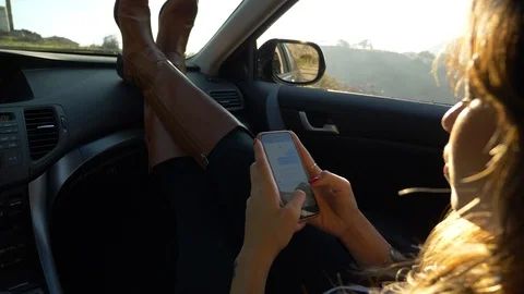 Young woman using smartphone in car Stock Footage
