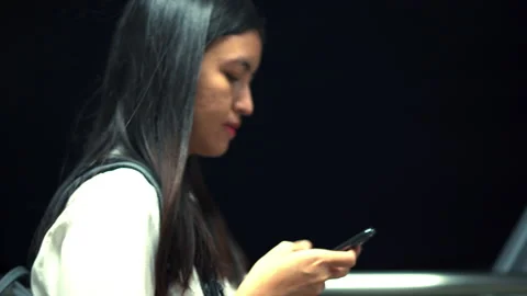 Young woman using smartphone on corridor at night time in Thailand. Stock Footage 233279228