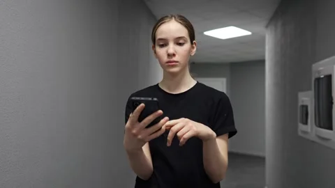 Young woman using smartphone in corridor Stock Footage 330102801