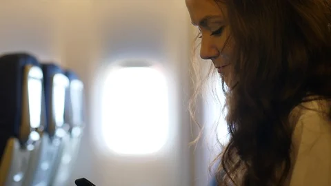 Young woman using smartphone inside airplane Stock Footage 94151046
