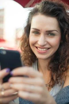 Young woman using smartphone, smiling, portrait Stock Photos