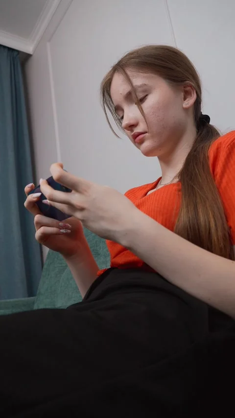 Young woman using smartphone on sofa at home 库存影片 311815324