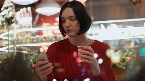 Young woman using smartphone taking selfie sitting inside of cafe behind window Stock-Footage 83081644