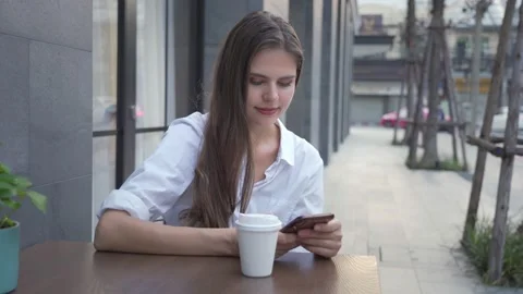 Young woman using smartphone texting sharing messages on social media enjoyin Stock Footage 143330904