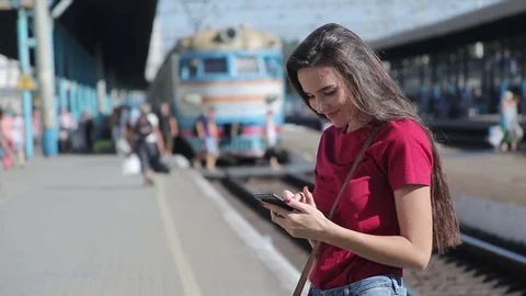 Young woman using smartphone at train station Video stock 78884440