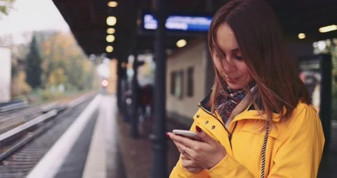 Young Woman Using Smartphone at the Train Station. SLOW MOTION 4K. Stock Footage 140367514