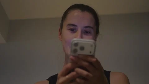 Young woman using smartphone in a warm bedroom... Video stock 337971546