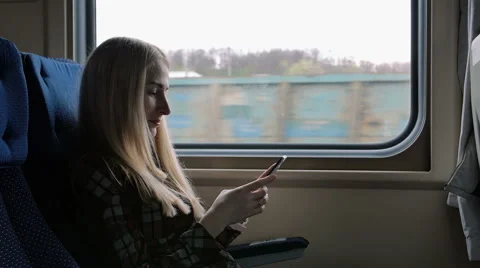 Young woman using smartphone while traveling by train 스톡 동영상 62648575