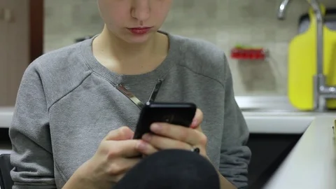 Young woman using smartphone while doing homework Stock Footage 87351445