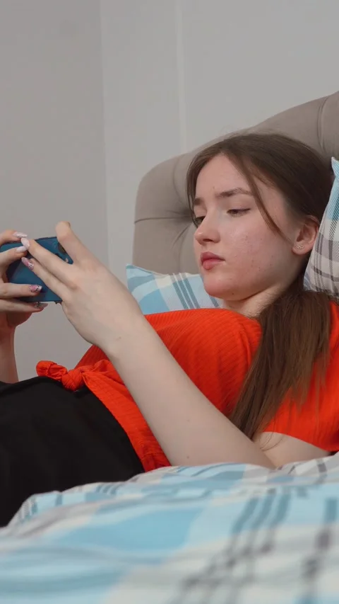 Young woman using smartphone while relaxing on bed Stock Footage 311781256