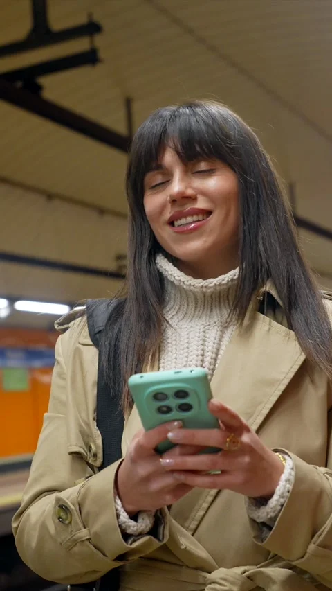 Young woman using smartphone while waiting in a subway station Stock Footage 328911523