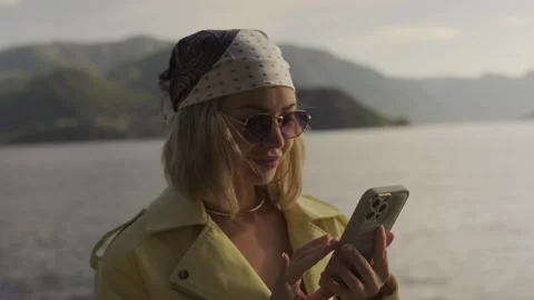 Young woman using a smartphone while traveling across Lake Como, Italy. Scenic 库存影片 336378706