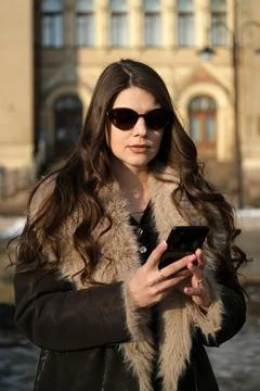 Young woman using smartphone while standing outdoors in historic city cente.. Foto stock
