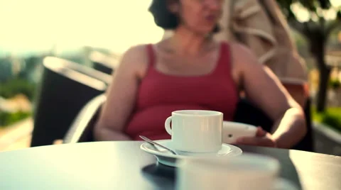 Young woman using tablet and drinking coffee outside on sunny morning. Видео 58278943