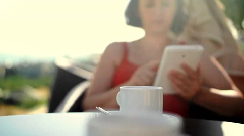 Young woman using tablet and drinking coffee outside on sunny morning. Video stock 58280071
