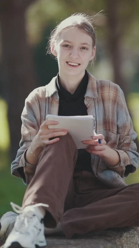 Young woman using tablet and stylus in park Stock Footage 327336657