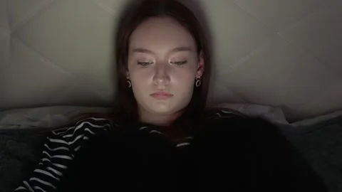 Young woman using tablet in bed at night Stock Footage 317757516