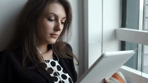 Young woman using tablet in coffee shop with headphone Stock Footage 64917537