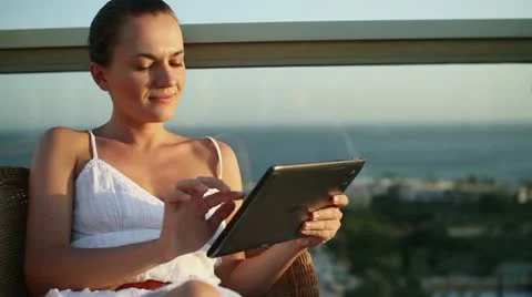 Young woman using tablet computer while relaxing on terrace  HD Stock Footage 10888684