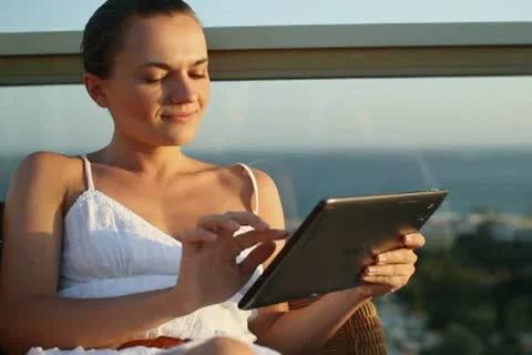 Young woman using tablet computer while relaxing on terrace  NTSC Stock Footage 10888689