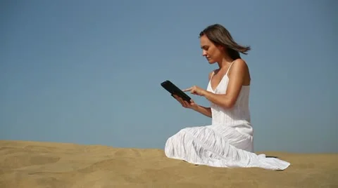 Young woman using tablet computer on the beach HD Stock Footage 10902029