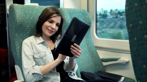 Young woman using tablet computer while sitting in train  HD Stock Footage 50169405