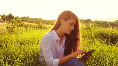Young Woman Using Tablet Computer Touchscreen Outside in Nature Stock Footage 56025714