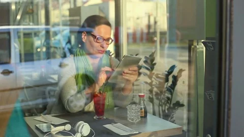 Young woman using tablet computer in cafe Stock Footage 70999602