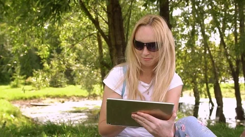 Young woman using tablet computer in the Park, slow motion. Stock Footage 78727966