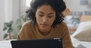 Young Woman Using Tablet Computer Relaxing On Bed Browsing Internet Typing Stock Footage