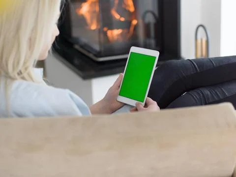 Young woman using tablet computer in front of fireplace beautiful young wo... Stock Photos