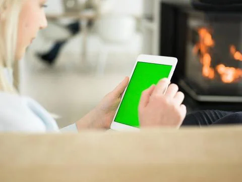 Young woman using tablet computer in front of fireplace beautiful young wo... Stock Photos